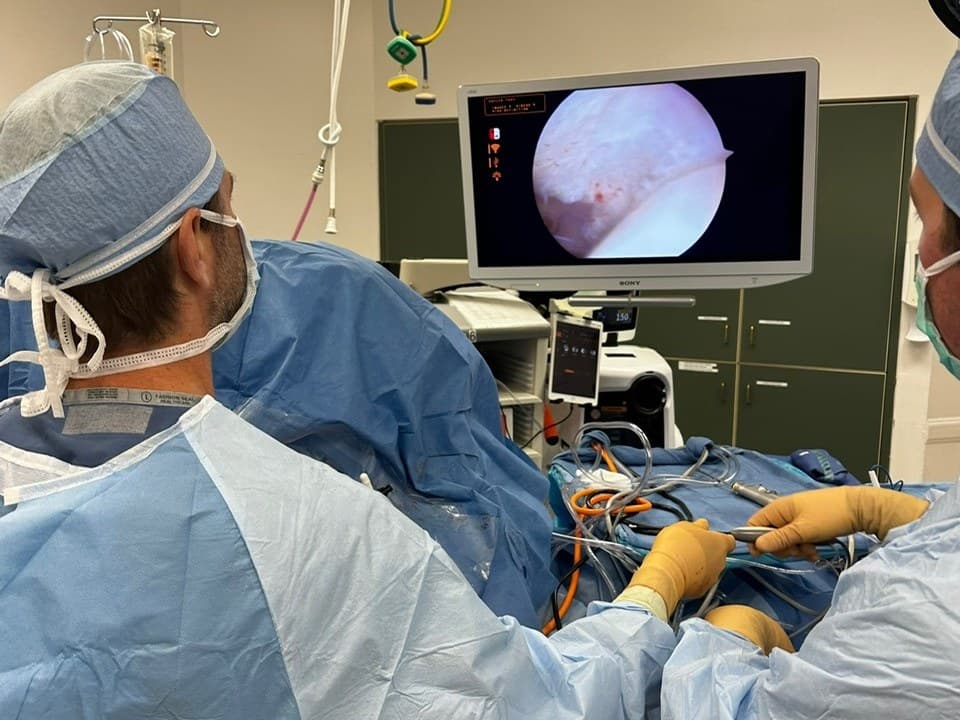 Dr. Jason Jones performing arthroscopic surgery, watching the camera view of the joint on the monitor