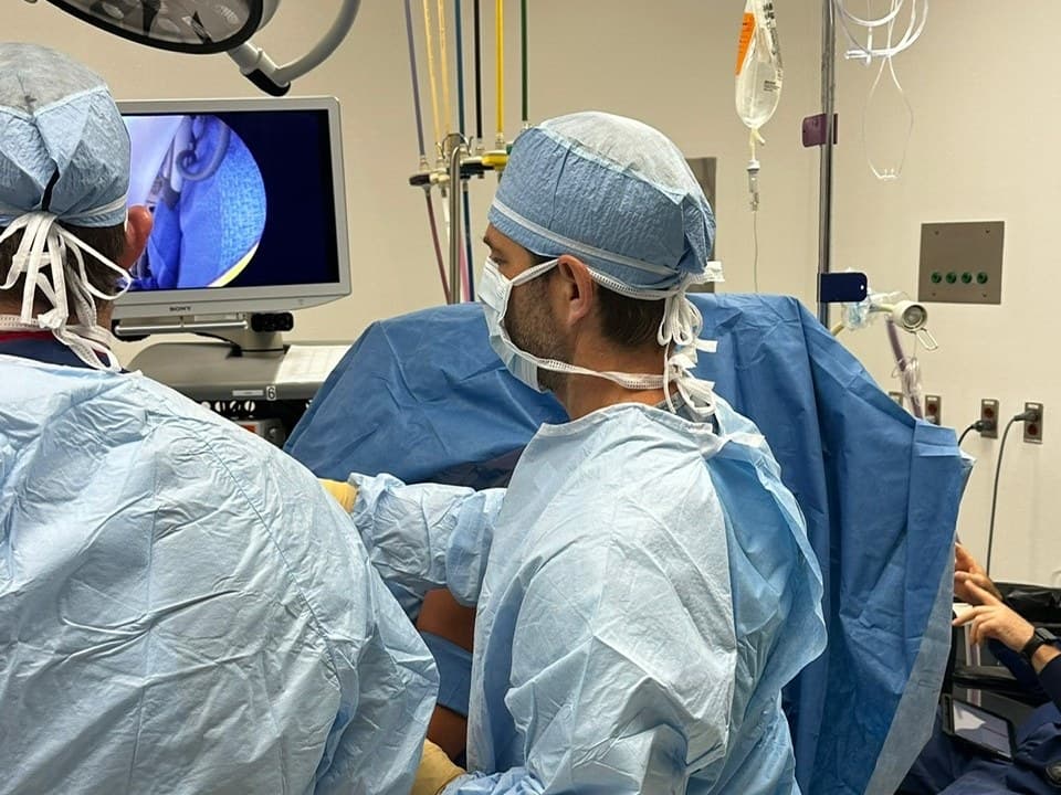 Dr. Jason Jones at the operating table, the arthroscope's camera view on the screen beside him