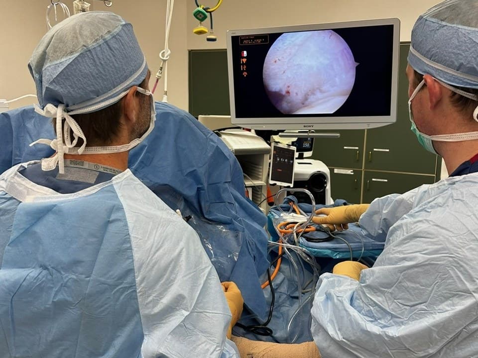 Dr. Jason Jones and his surgical team during an arthroscopic procedure, with the joint on the monitor