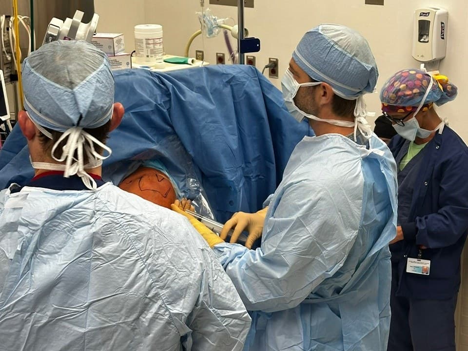 Dr. Jason Jones operating on a shoulder with his surgical team
